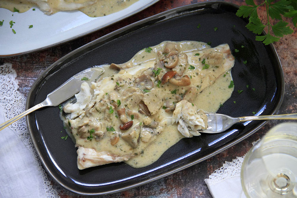 Lubina con salsa de vino blanco y setas