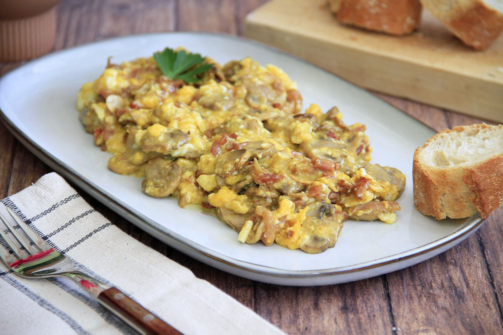 Huevos revueltos con beicon y champiñones salteados